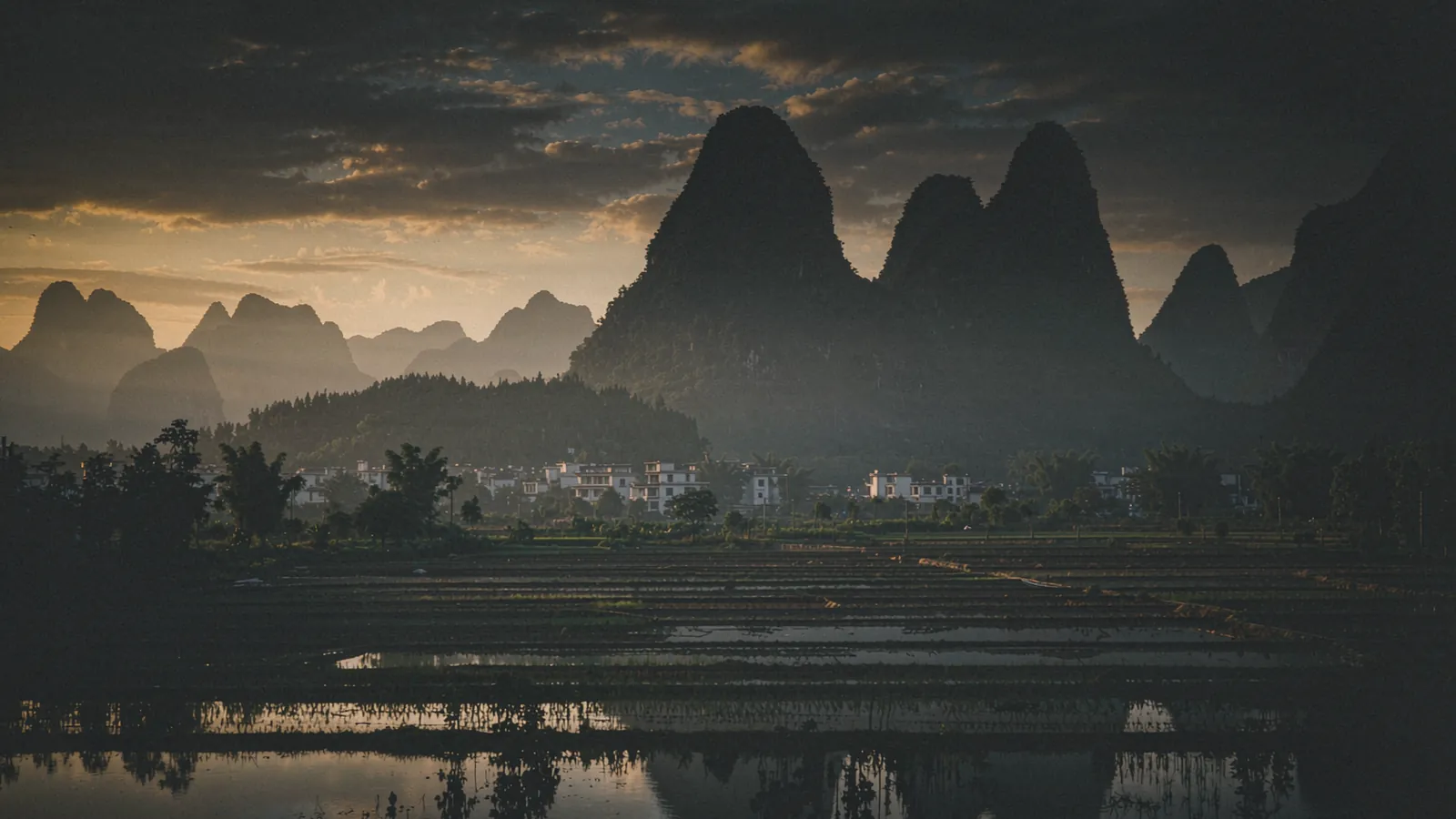 Rio com montanhas cársticas e barcos de bambu, sob luz baixa da manhã