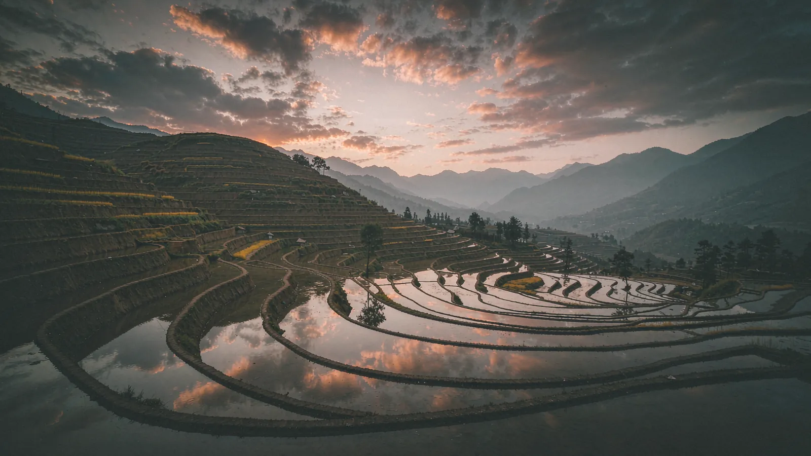 Aldeia no Yunnan com montanhas ao fundo e campos cultivados, ao amanhecer