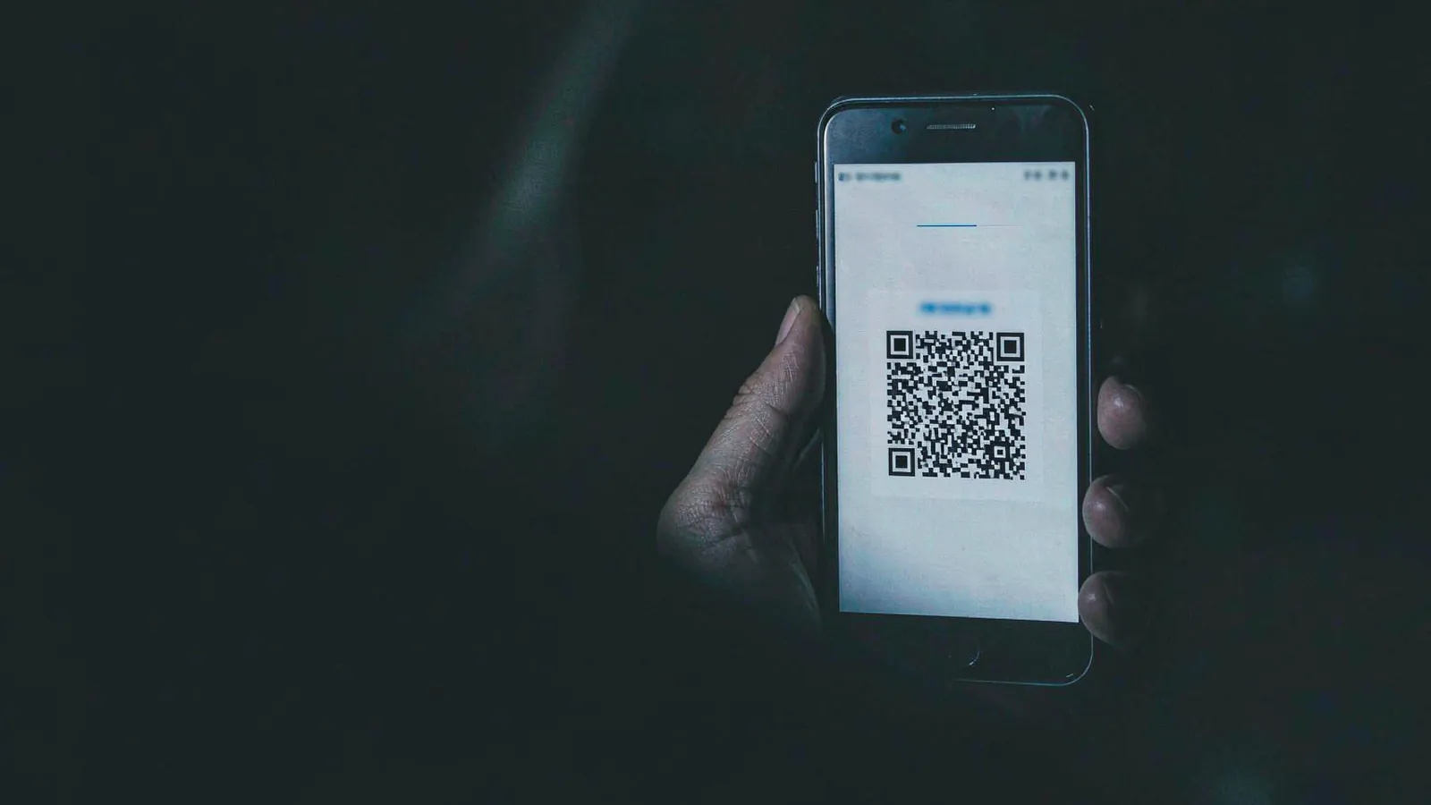 Telemóvel sobre a mesa de um restaurante, a mostrar um código QR de pagamento